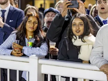 Young racegoers watch the racing at Wolverhampton from the trackside
