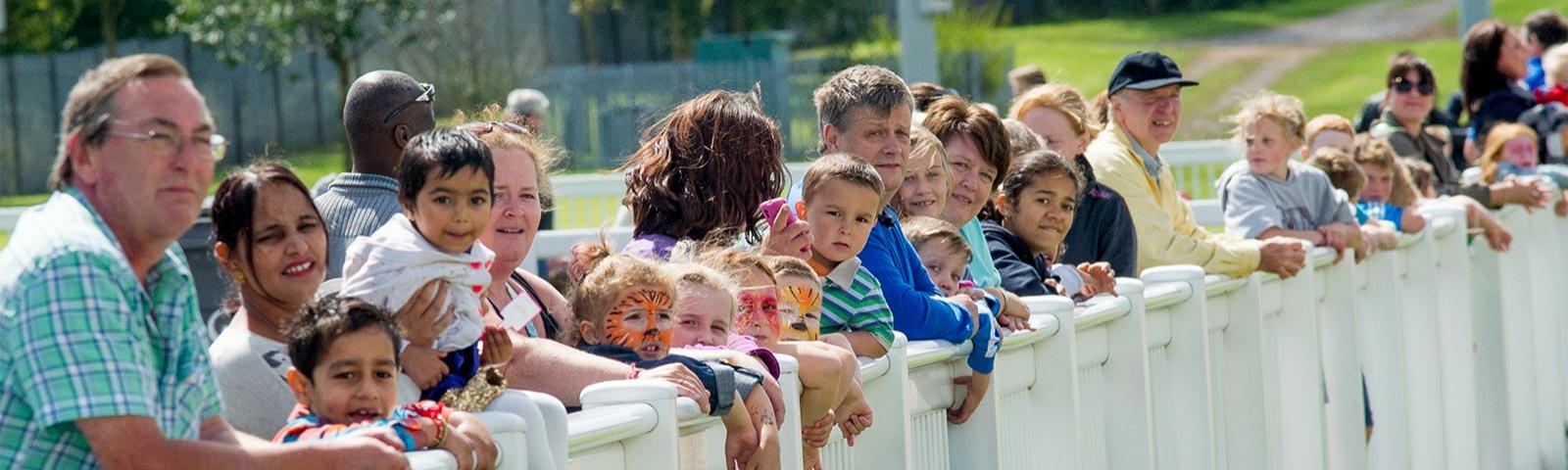 Families with face painted children gather to watch the race.