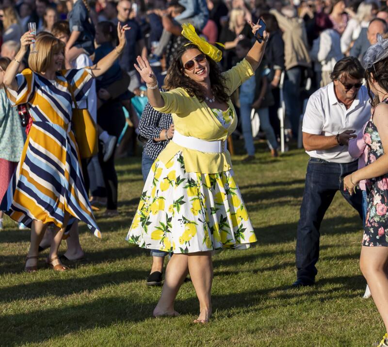 A lady dressed for the races dancing to music at Wolverhampton Racecourse.