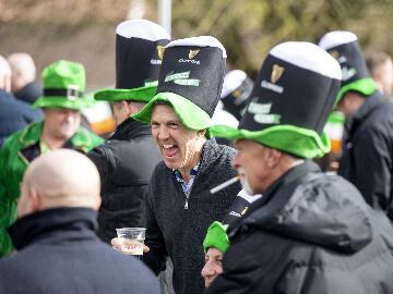 A group of race goers in St Patricks Day hats enjoying their day.