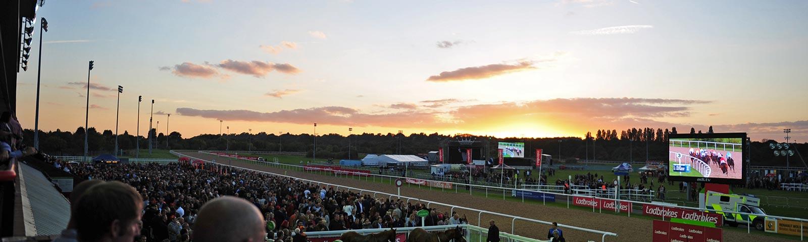Racing at dusk at Wolverhampton Racecourse.