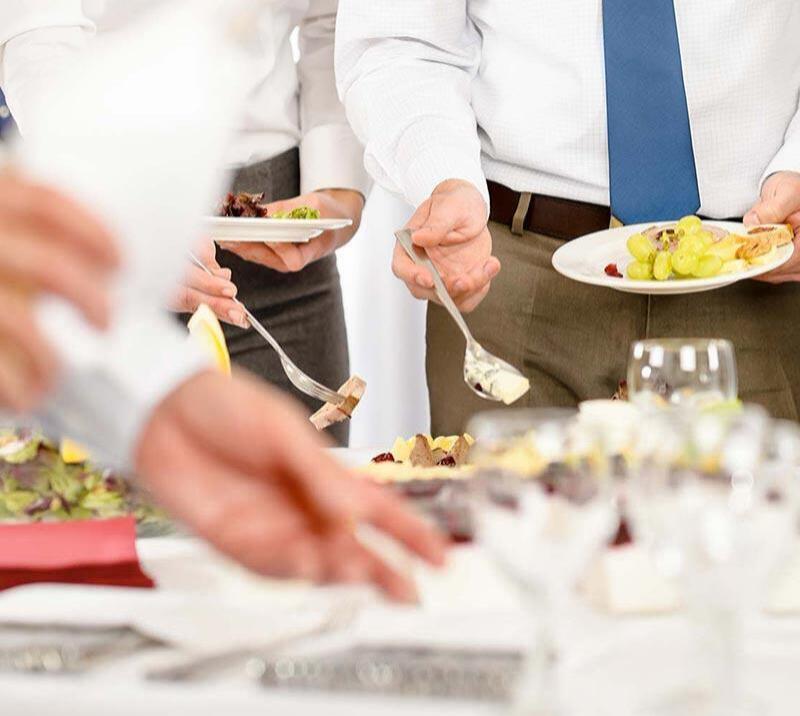 Group of men eating food from a buffet.