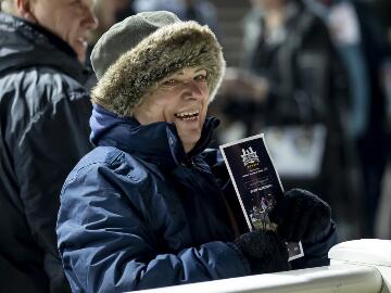 A race goer dressed for the cold smiles at the trackside at Wolverhampton Racecourse