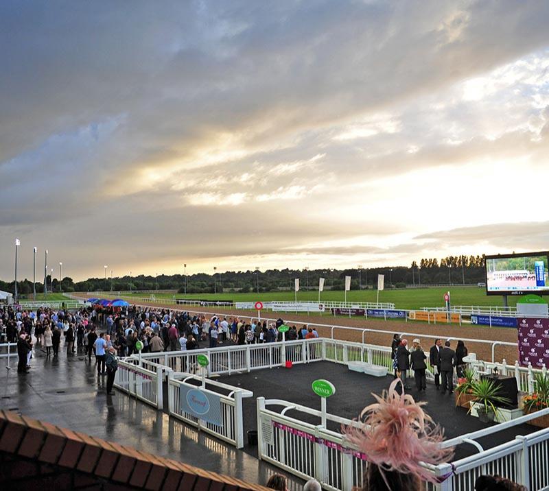 Crowds watching the racing next to the winners enclosure.